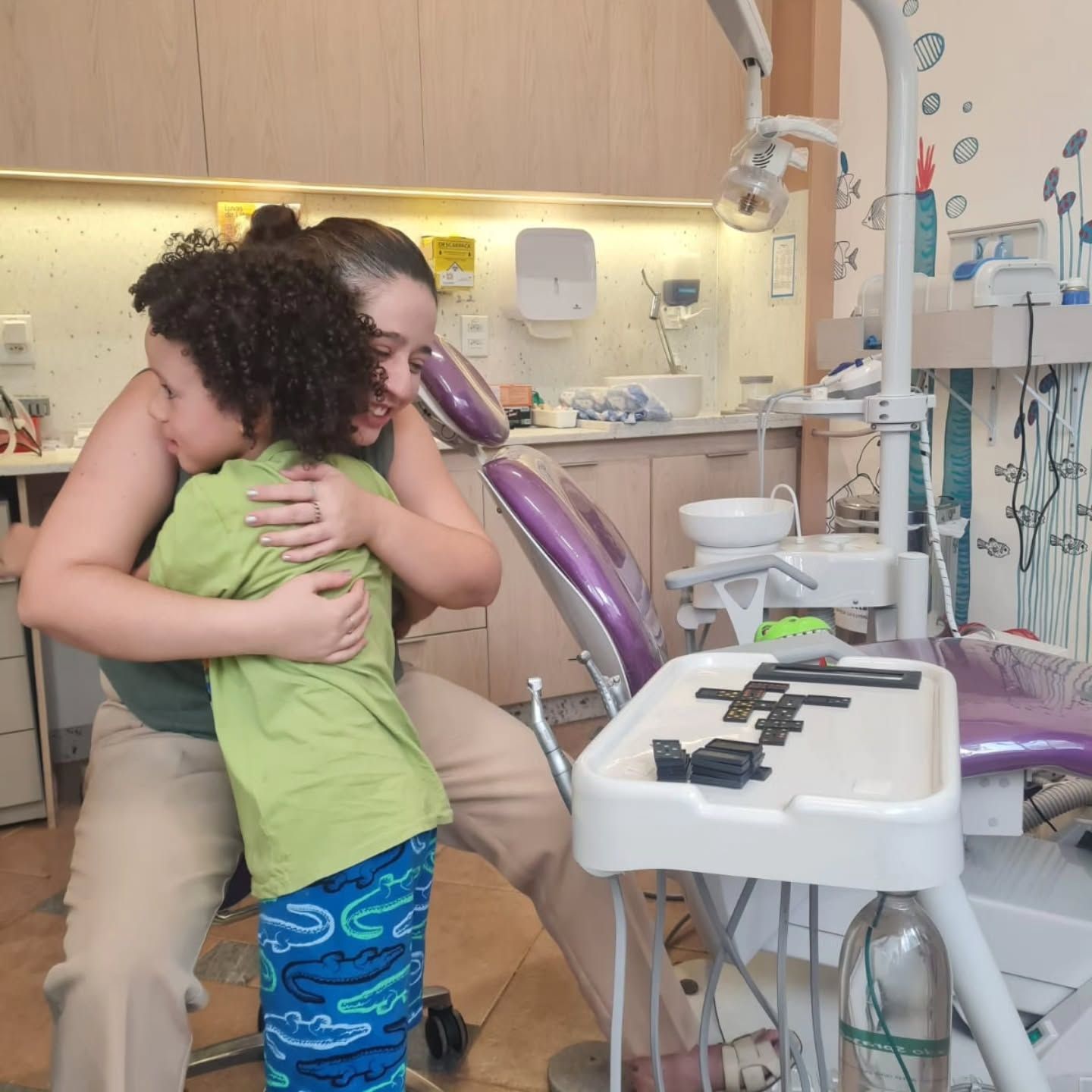 Criança abraçando a dentista no consultório depois da consulta