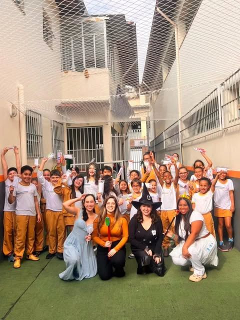 Equipe da Odonto Raiz fantasiada com alunos de uniforme em uma escola de Mariana